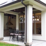 Recessed Portico-Kitchen Aid outdoor gas grill & storage, covered beadboard ceilings, ceiling fans, recessed lighting, and a fenced backyard.