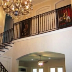 Foyer showing dramatic wrought iron stair case.