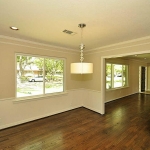 Contemporary chandelier in Dining Room shows off gleaming hardwoods.