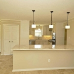 Kitchen is subtlely set apart from den with the wide breakfast bar.