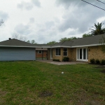 Back view showing garage with covered walkway to house.