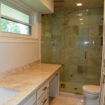 Master bath, crema-marfil counter and seamless glass shower.