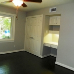 Bedroom two with built in planning/study area, wood floors.