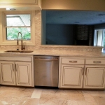 Stainless Commercial Dishwasher, double stainless steel sink under large window.