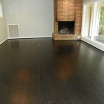 Wood floors in family room with wood burning fire-place. Open to kitchen with breakfast bar.